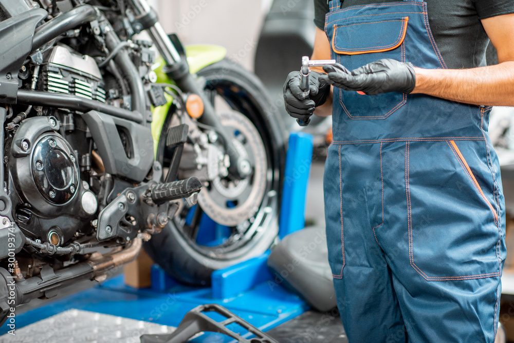 Mechanic repairing motorcycle at the workshop