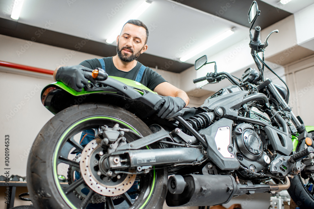 Worker repairing motorcycle in the workshop