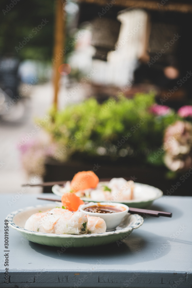 Asian Vietnameese lunch. Fresh vegan rice paper summer rolls on table in Asian cafe. Vietnamese, ori