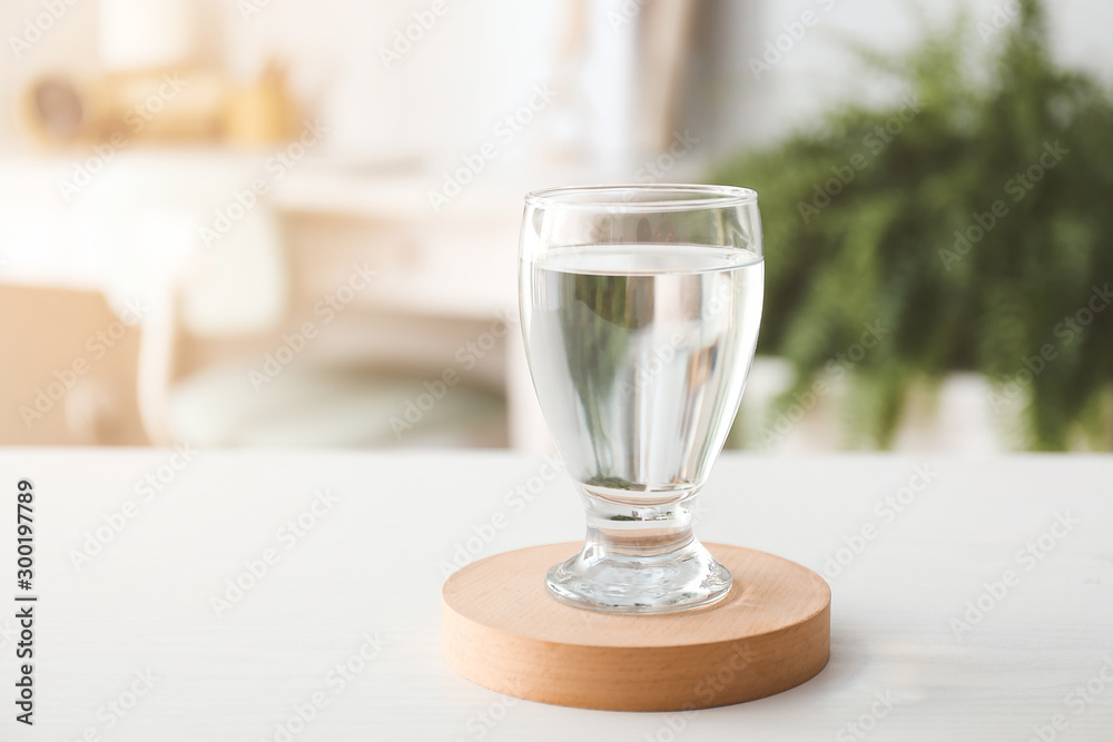 Glass of fresh water on table in room