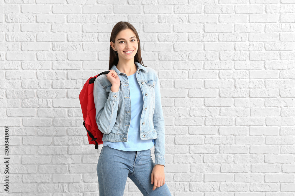 Portrait of teenage girl on brick background