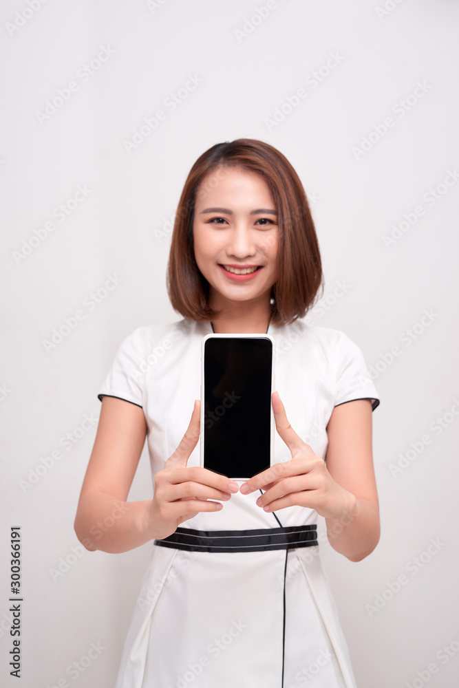 Beautiful Asian woman holding blank screen smartphone on white background