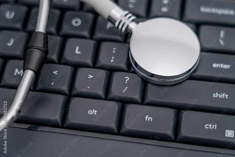 Stethoscope on black computer keyboard - network information leak concept picture