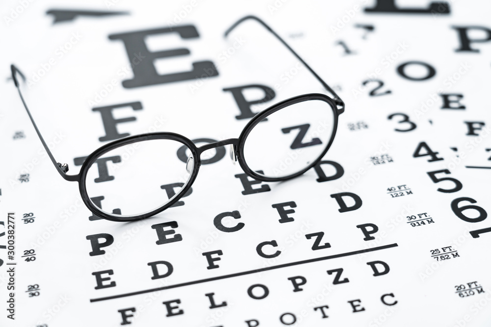 Black glasses on the eye chart with concept of vision protection