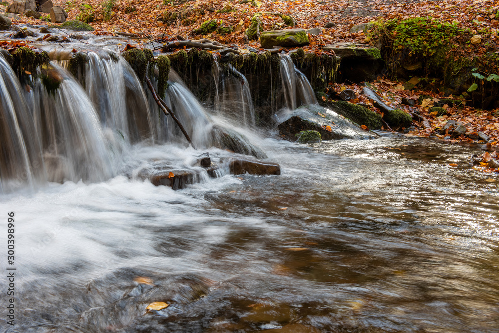 Colorful majestic waterfall in autumn forest