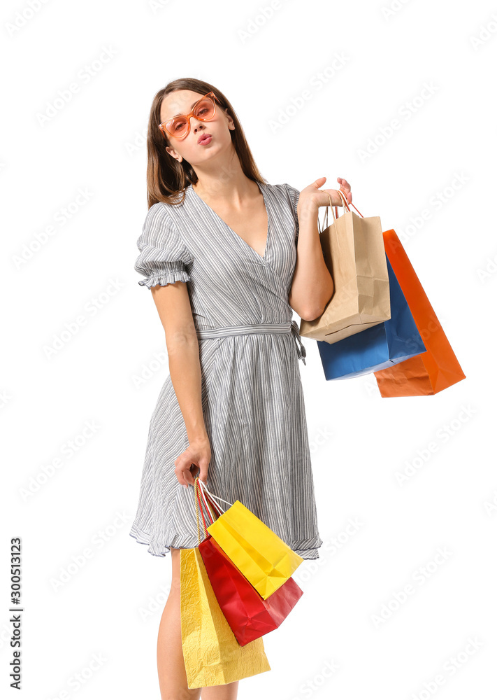 Beautiful young woman with shopping bags on white background