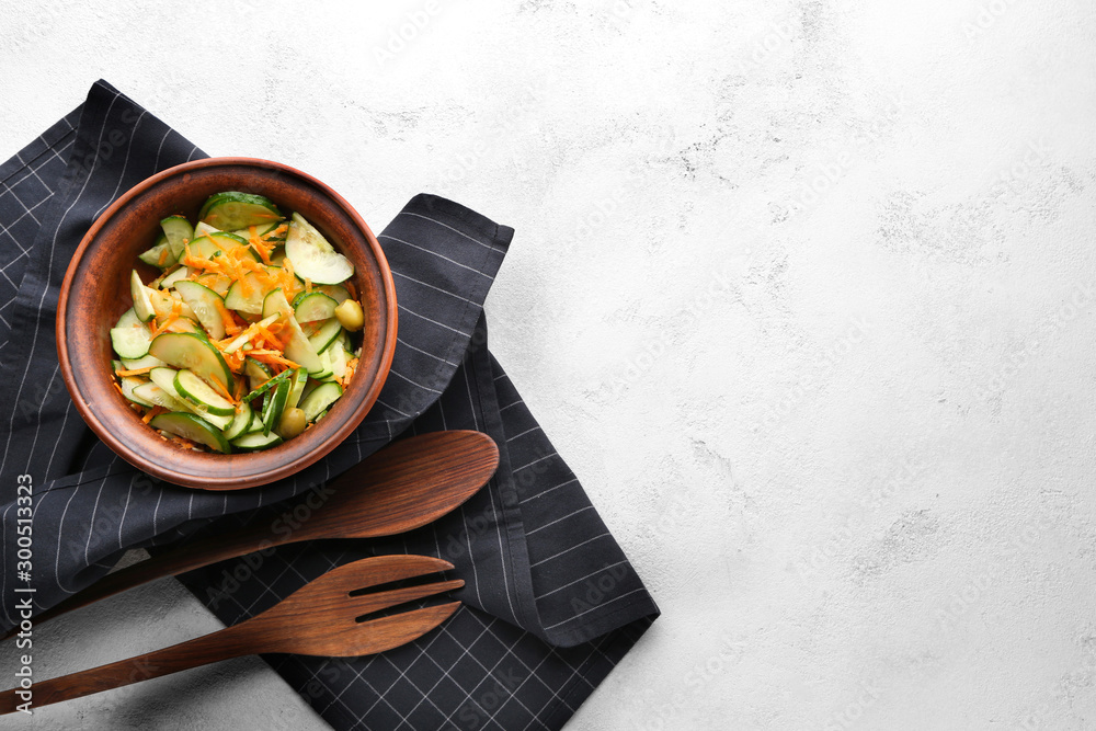 Bowl with fresh vegetable salad on light background