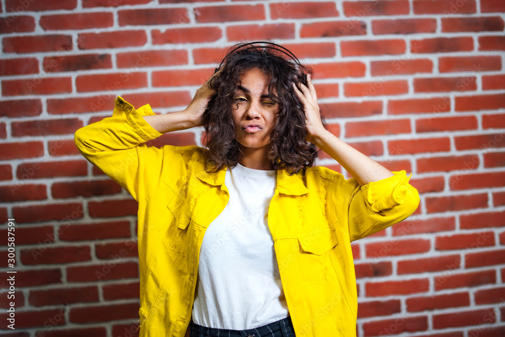 Positive human emotions. Portrait of happy emotional teenage girl with headphones, closed eyes, kiss