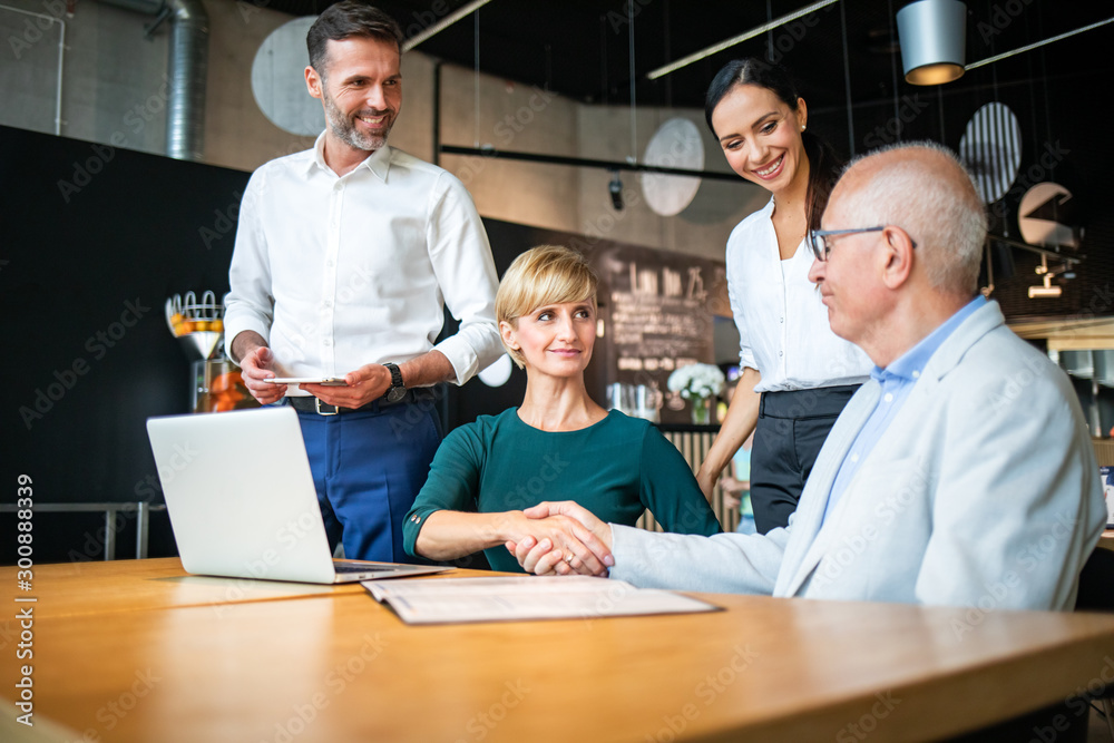 Group of business people signing a contract with handshake