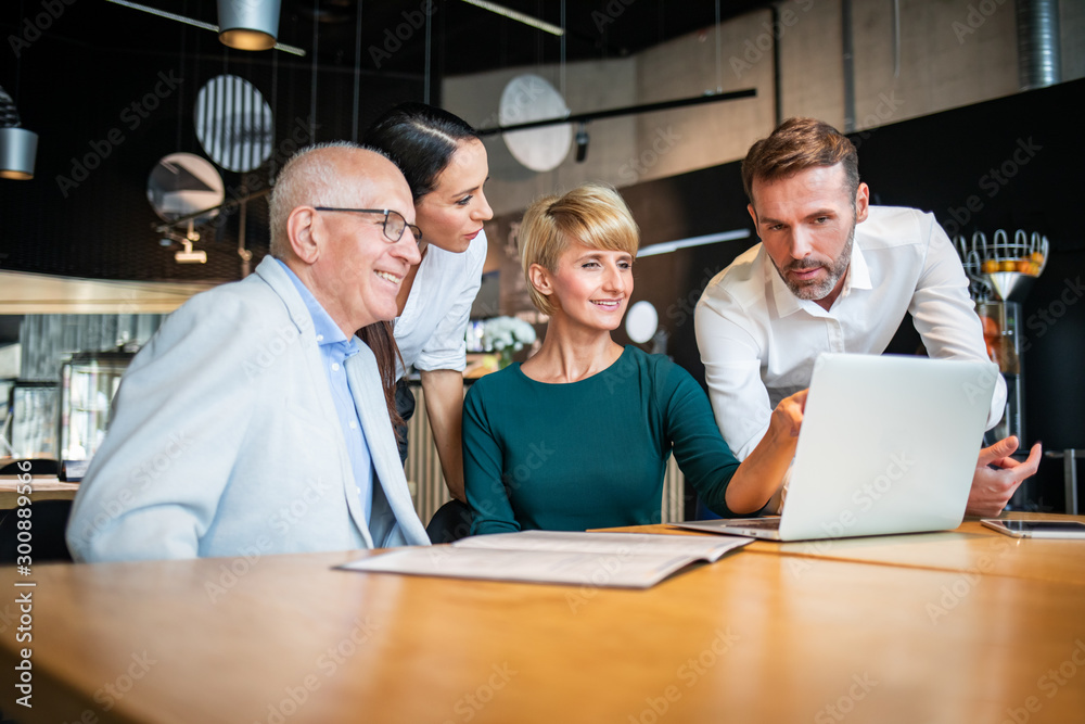 Group of business people with laptop meeting in cafe