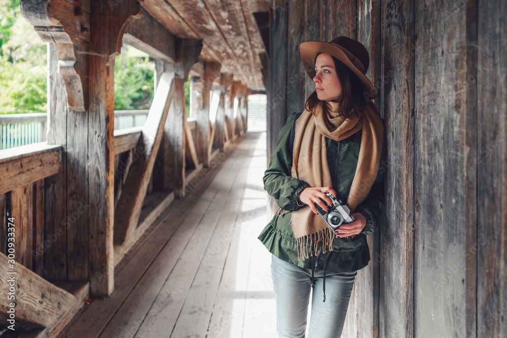 Young girl with a retro camera on a bridge