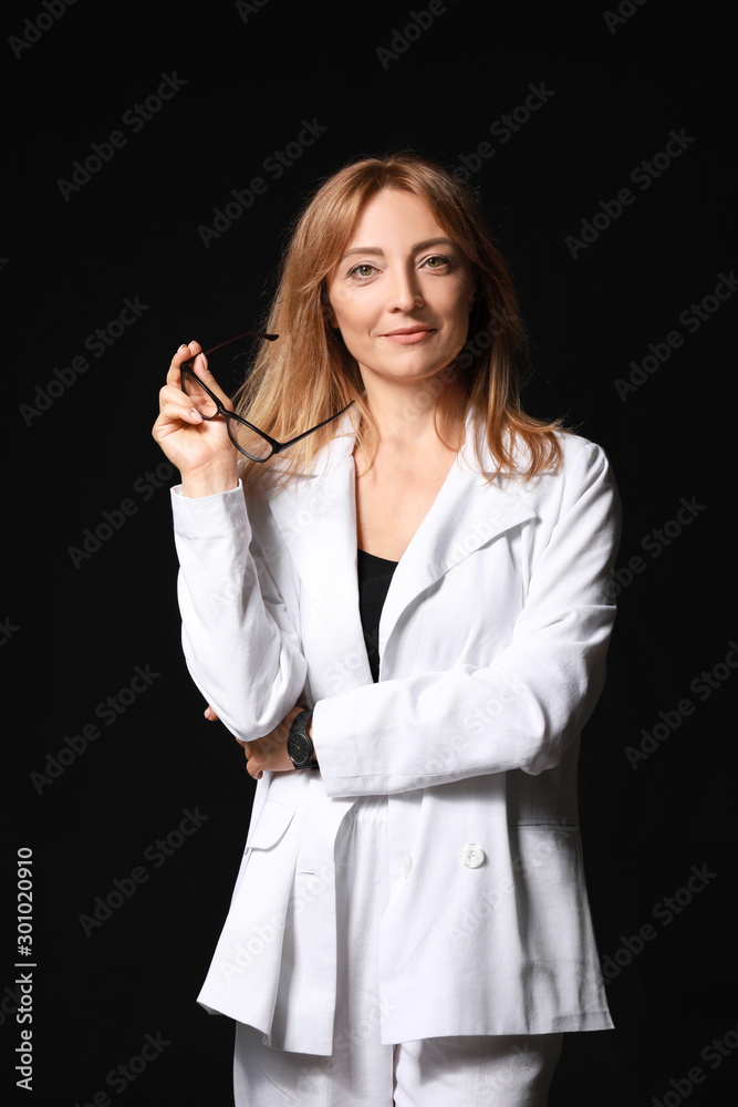 Stylish mature businesswoman on dark background