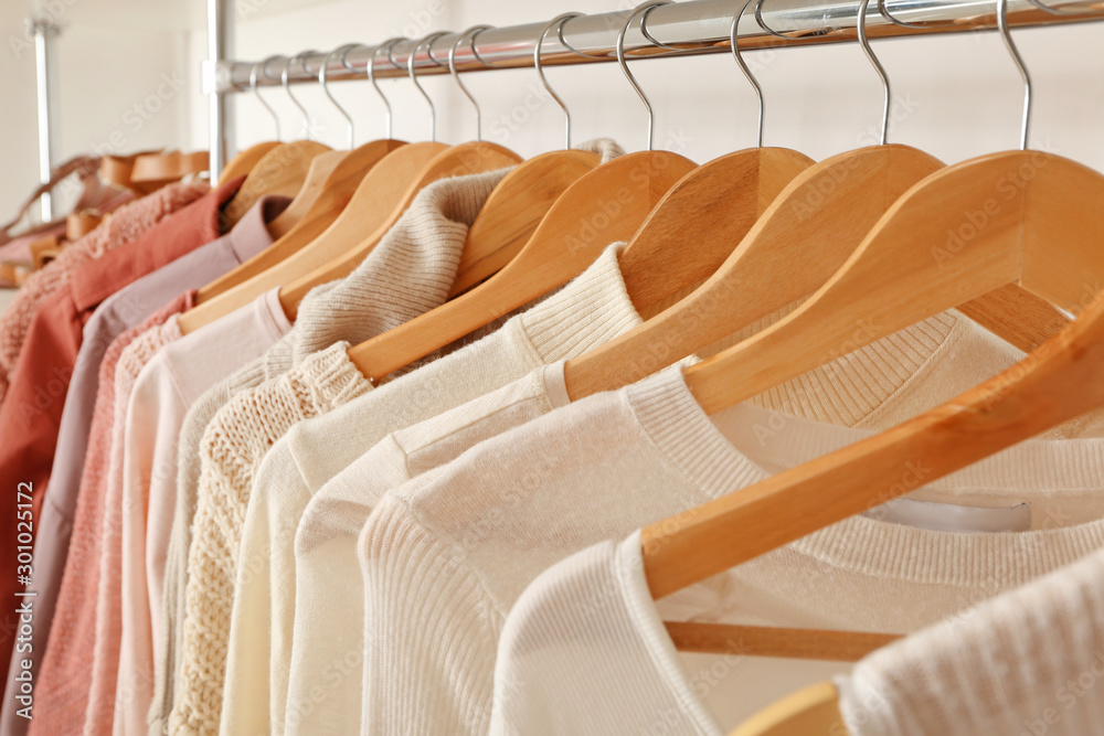 Stylish clothes on hangers in show room, closeup