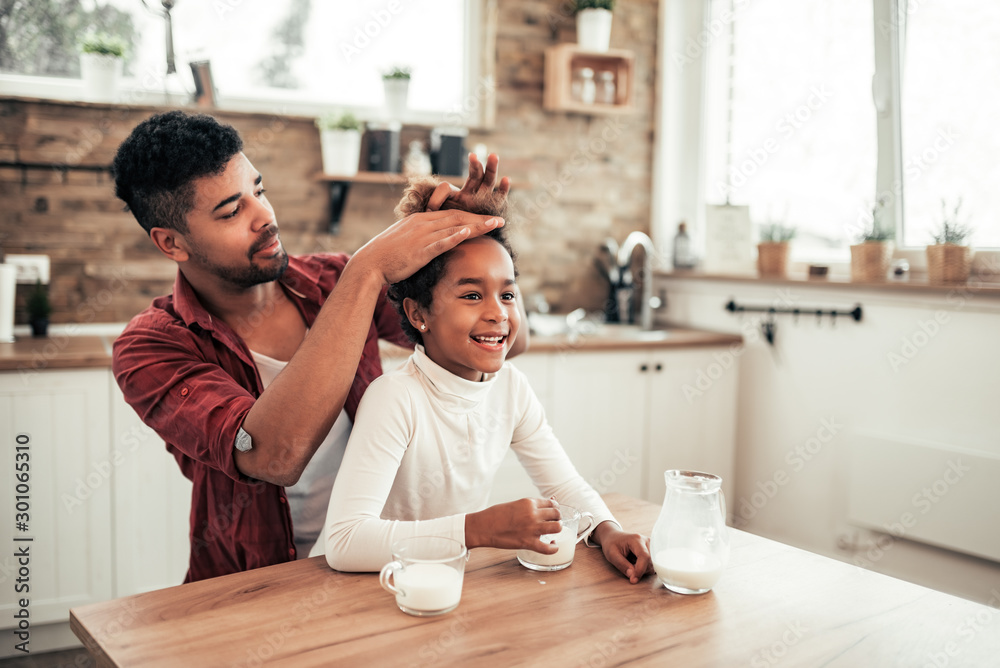 Loving father and daughter in the morning in the kitchen.