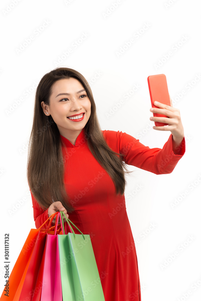 Beauty women wear aodai selfie while hold shopping bags in lunar new year