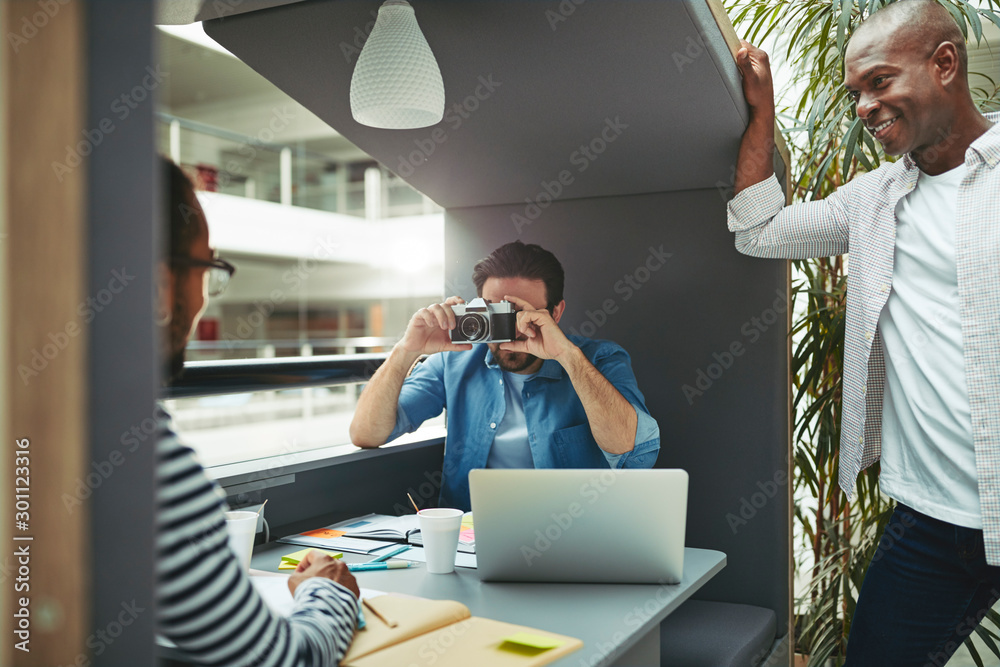 Designer taking a colleagues photo in an office meeting pod