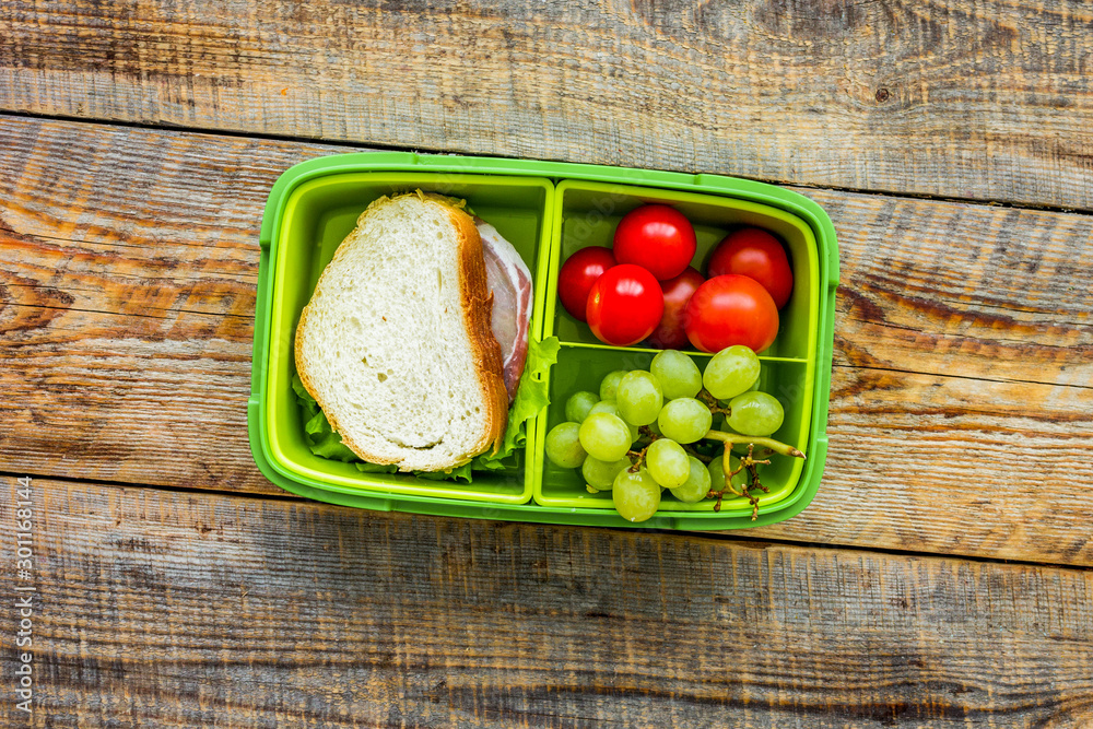 healthy break with cherry, grape and sandwich in lunchbox on home table flat lay