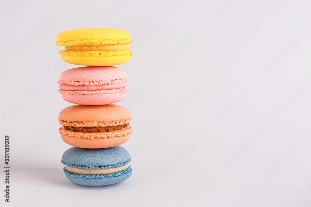 Different tasty macarons on light background