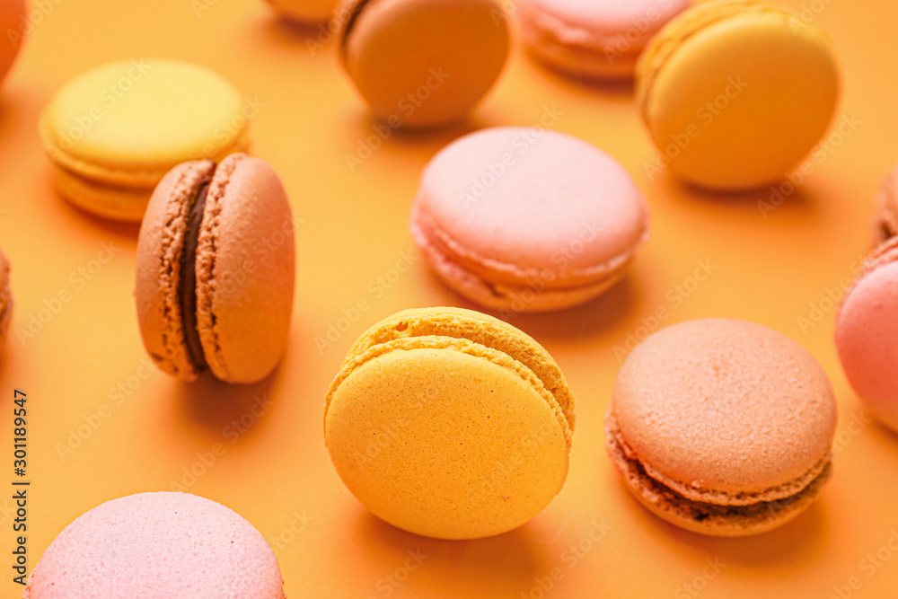 Different tasty macarons on color background