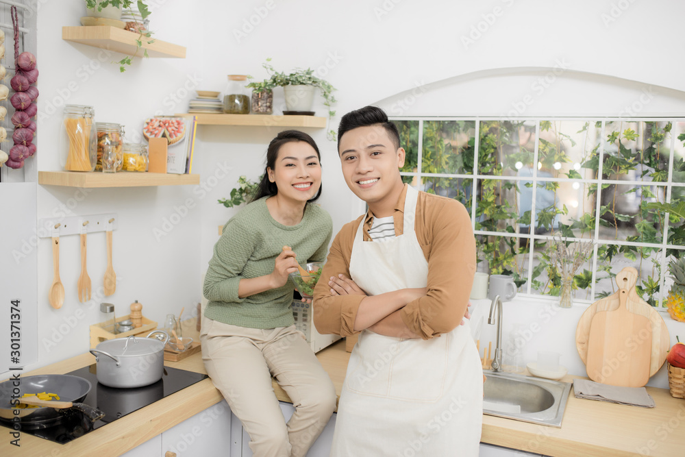 幸福的年轻夫妇在厨房里吃饭聊天