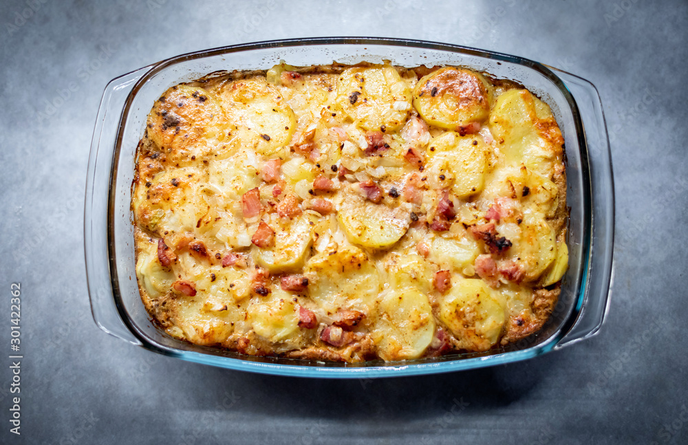 Freshly cooked casserole with potatoes, bacon and cheese close-up on the table top view