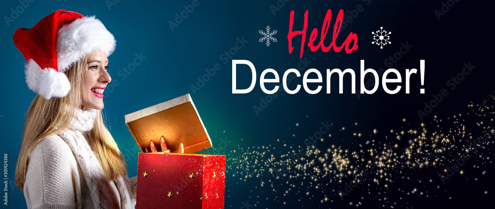 Hello December message with young woman with Santa hat opening a gift box