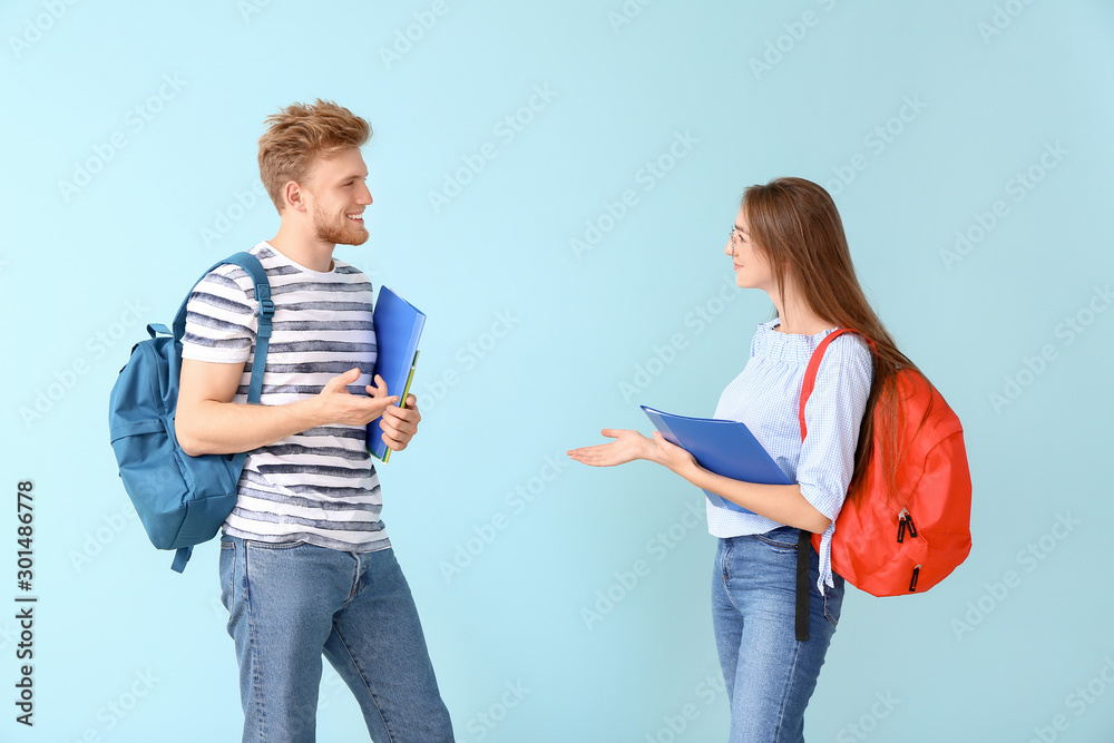 Portrait of female and male students on color background