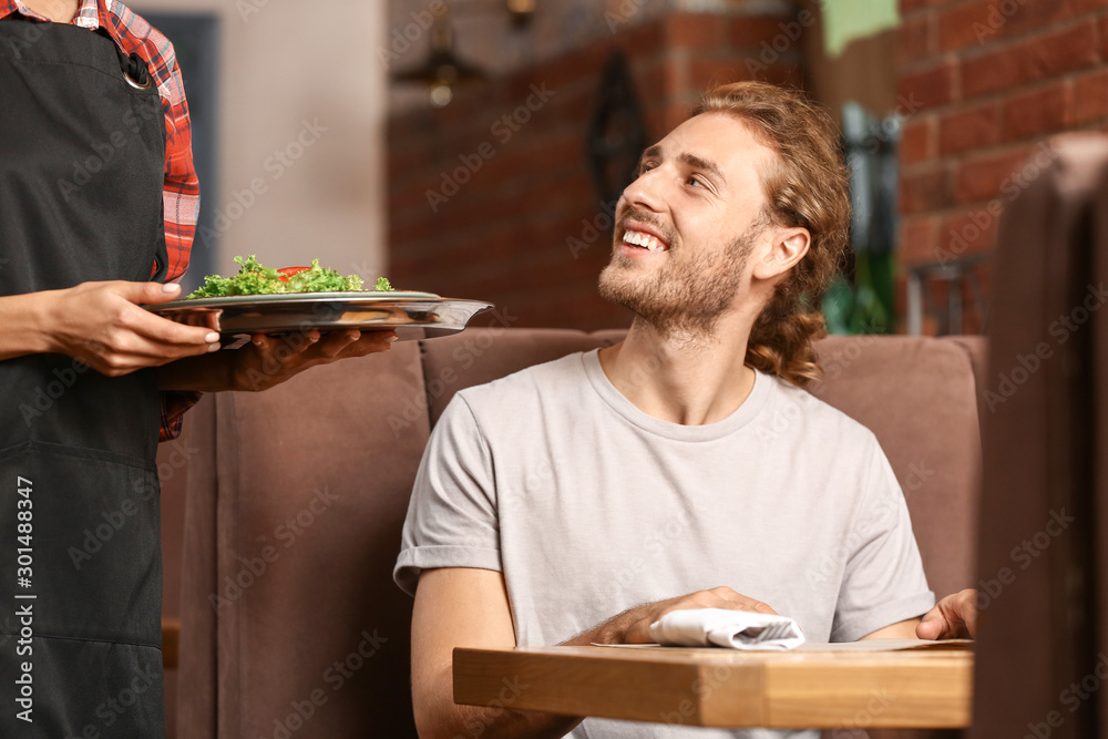 Waitress serving client in restaurant