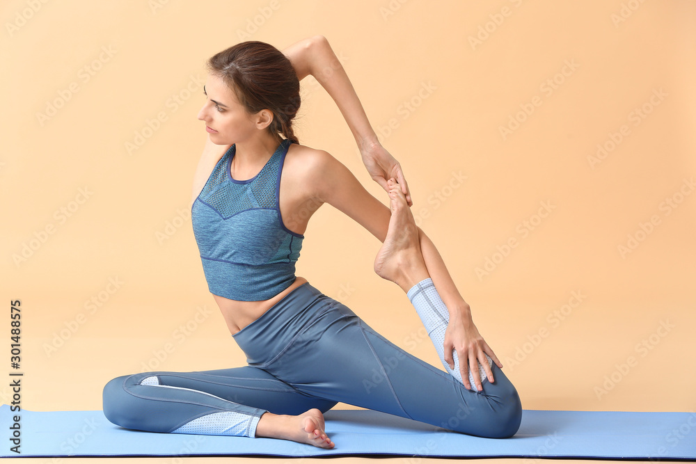 Beautiful young woman practicing yoga on color background