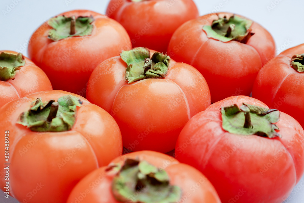 Ripe persimmons on light background, closeup