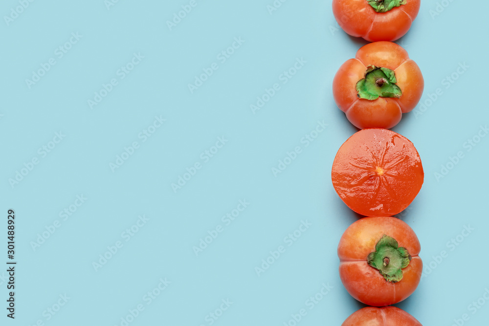 Ripe persimmons on color background