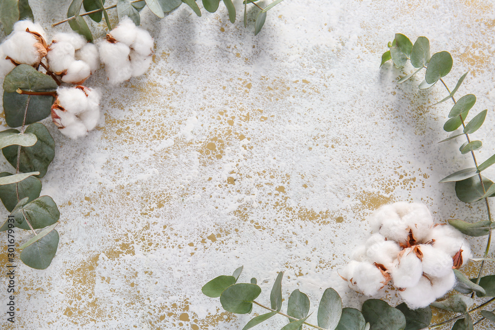 Beautiful cotton flowers and eucalyptus branches on light background