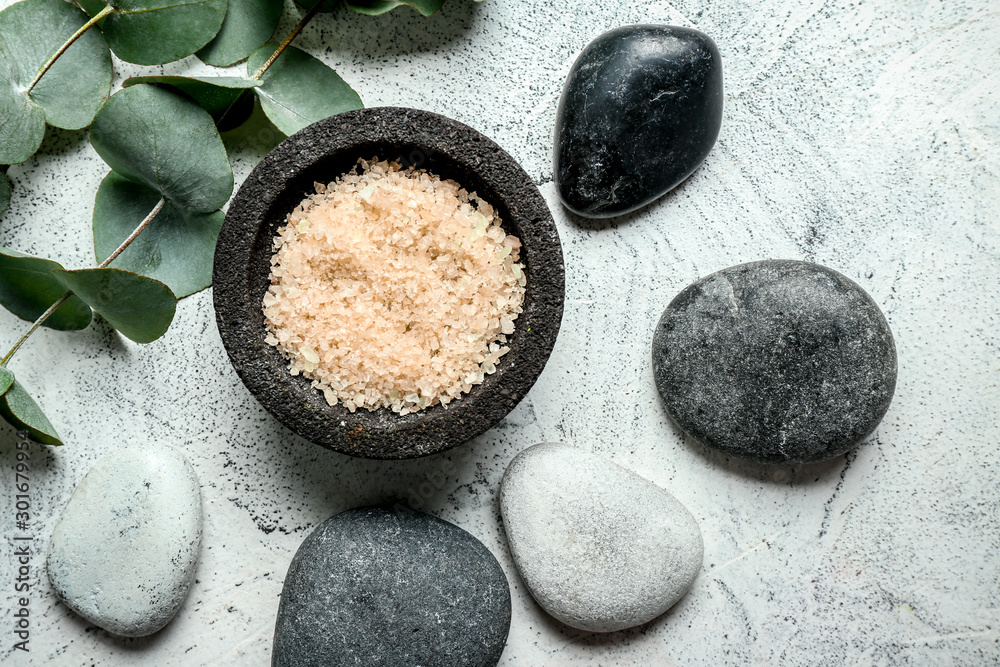 Spa composition with sea salt and stones on light background