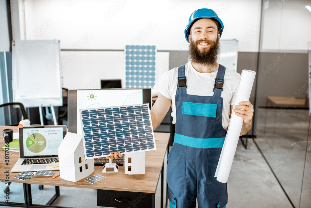 Portrait of a dedicated worker in workwear with blueprints and solar panel at the alternative energy