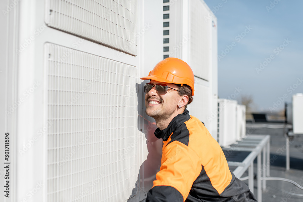 Workman installing outdoor unit of the air conditioner