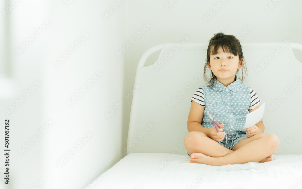 Portrait of a little asian girl cutting a paper in activities on DIY class at Home School.Scissors c