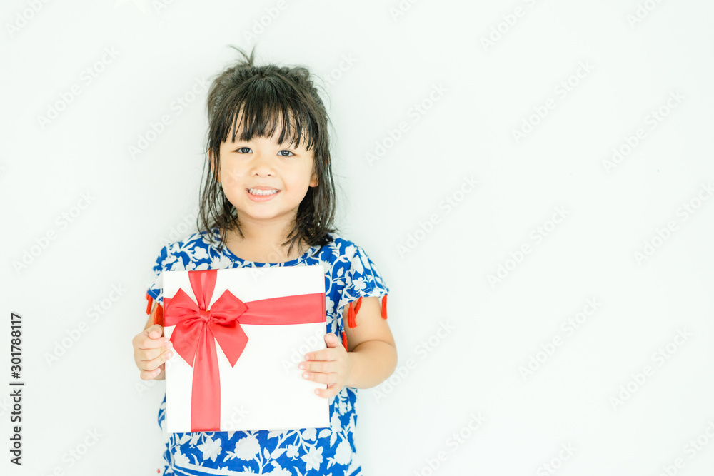 Little asian girl smile and holding red gift box on white background.child holding gift box.