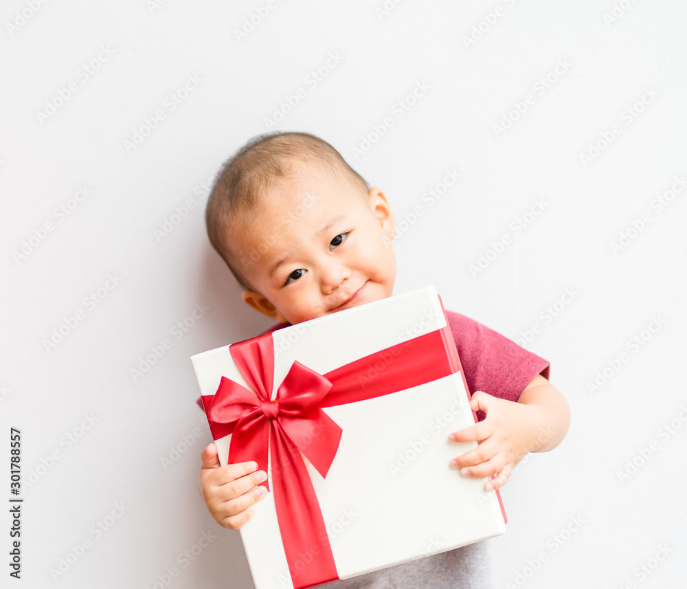 Cute little baby boy with gift box on white background.Handsome little asian baby boy with gift cele