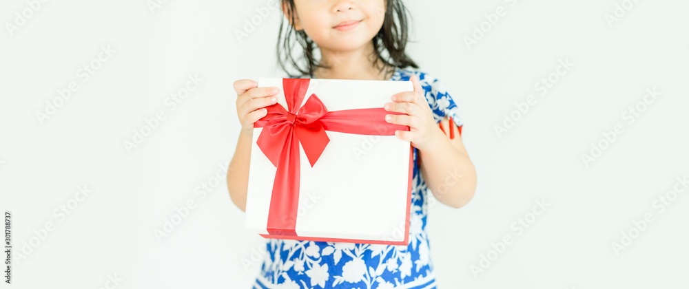 Little asian girl smile and holding red gift box on white background.child holding gift box.