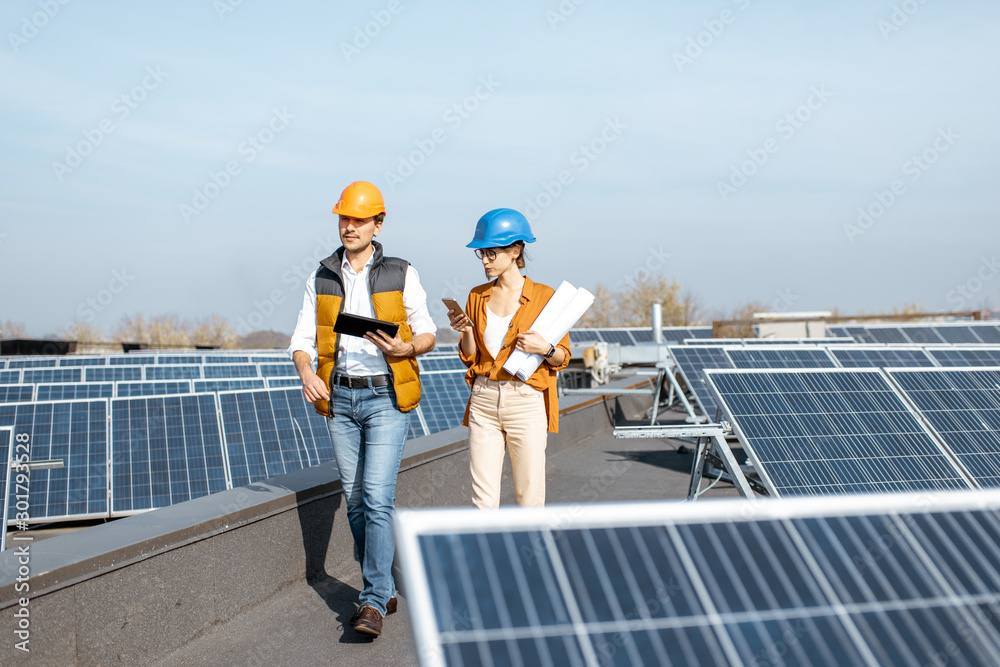 Two engineers or architects examining the construction of a solar power plant, walking with digital 