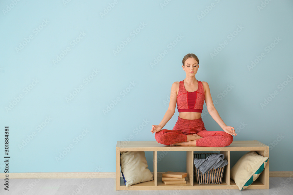 Young woman practicing yoga at home