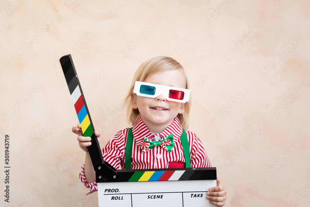 Funny kid holding clapper board