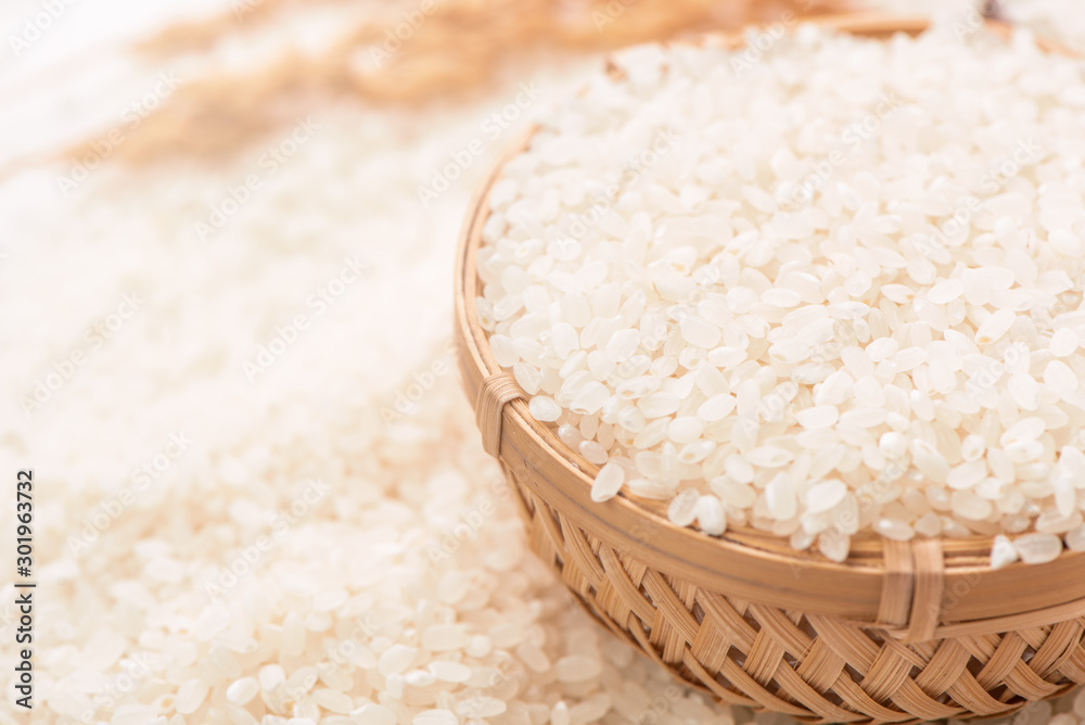 Raw white polished milled edible rice crop on white background in brown bowl, organic agriculture de