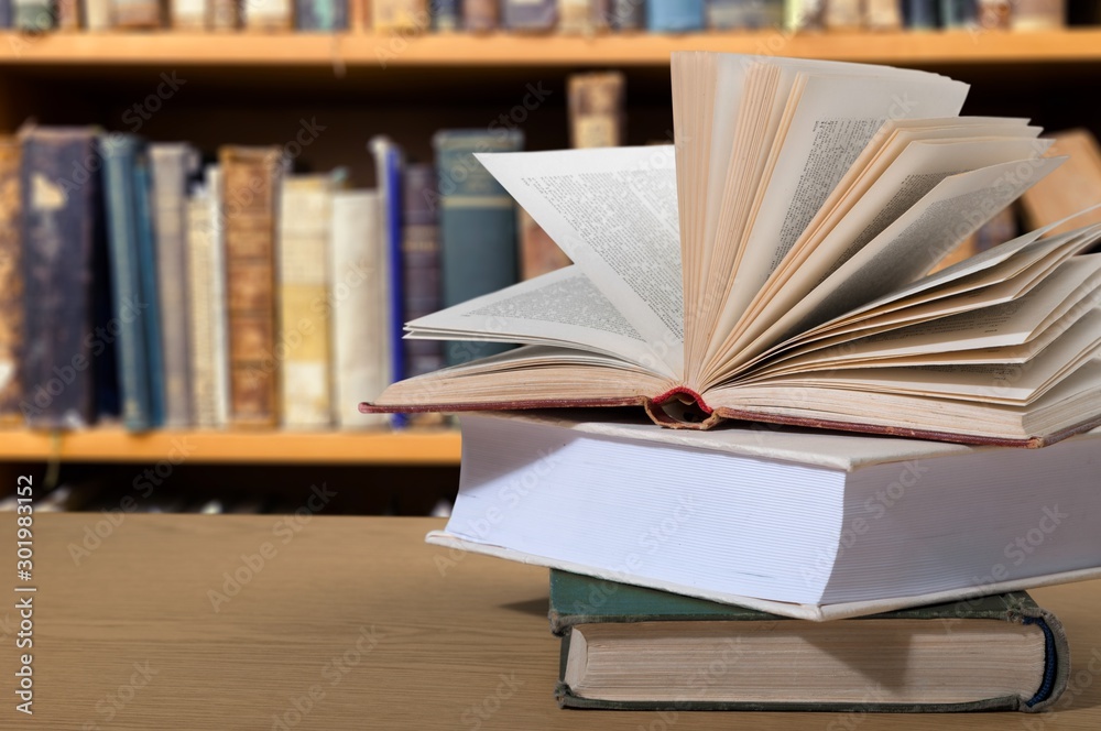 Close-up Black reading glasses and book on blurred library background