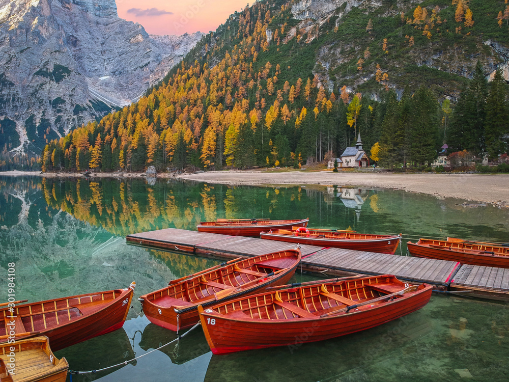 Boats on the Lago di Braies lake in Dolomites at sunrise, Italy