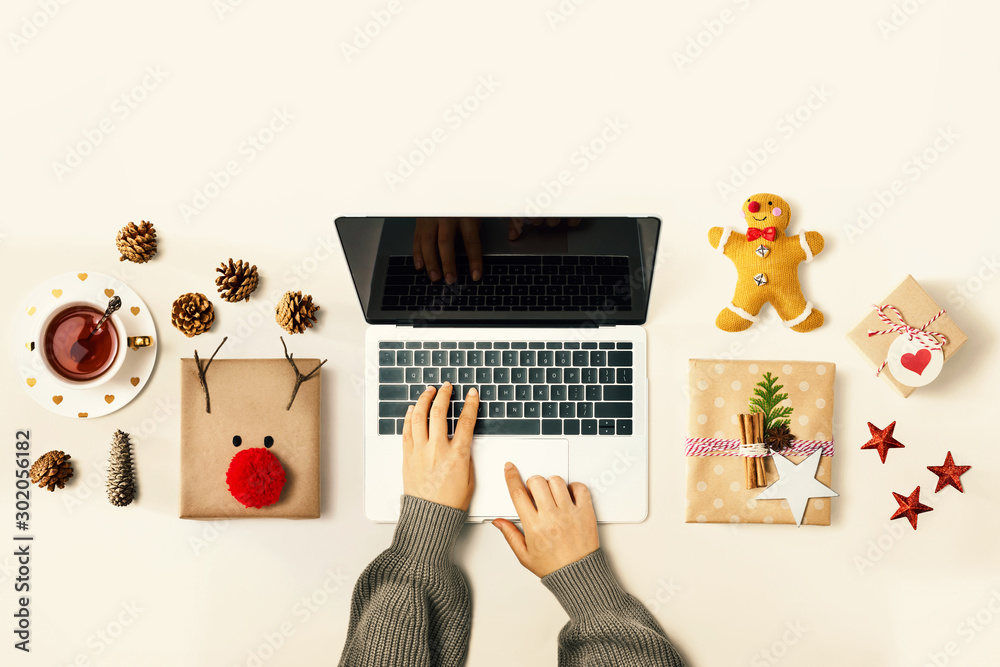 Christmas giftboxes with person using a laptop computer - overhead view