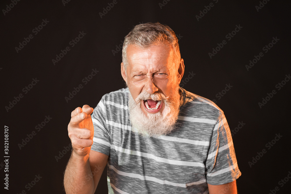 Angry mature man on dark background