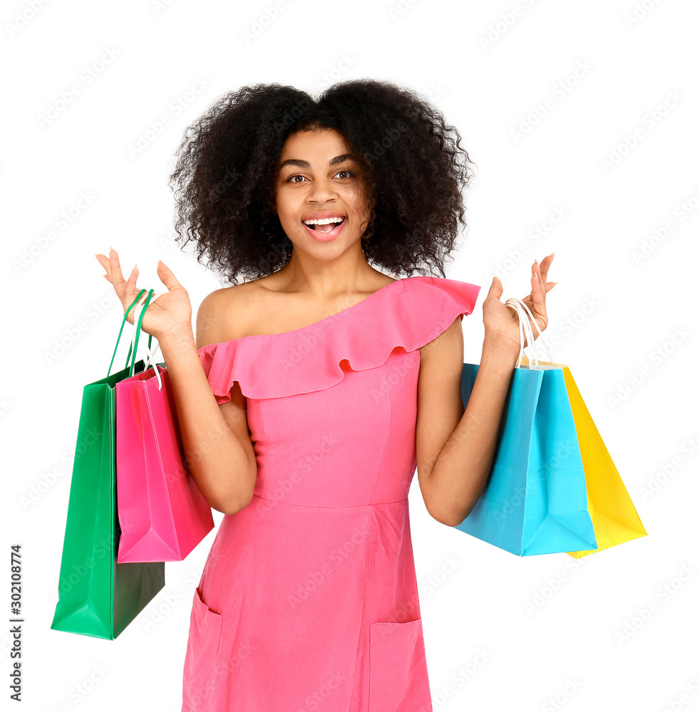 Beautiful African-American woman with shopping bags on white background