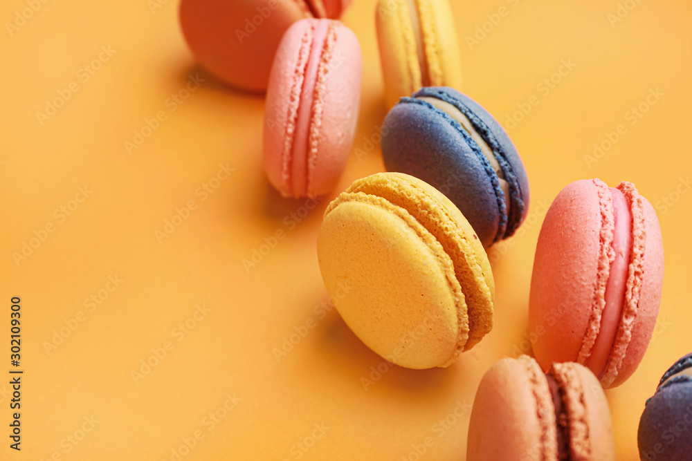 Different tasty macarons on color background