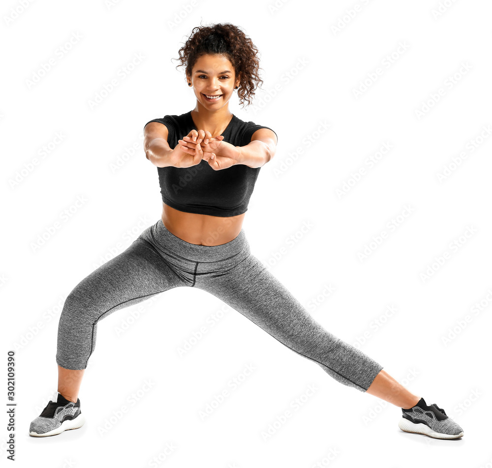 Sporty African-American woman training against white background